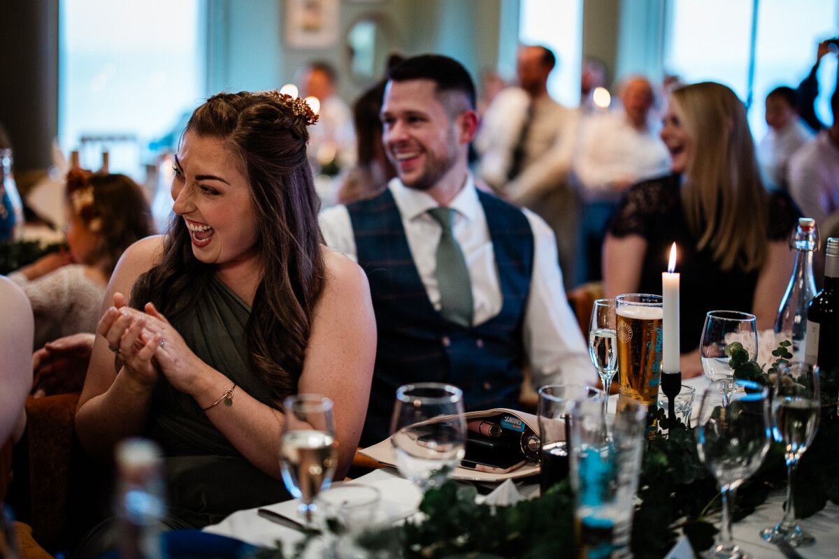 Wedding guests laugh at speeches during a wedding at Polurrian on the lizard