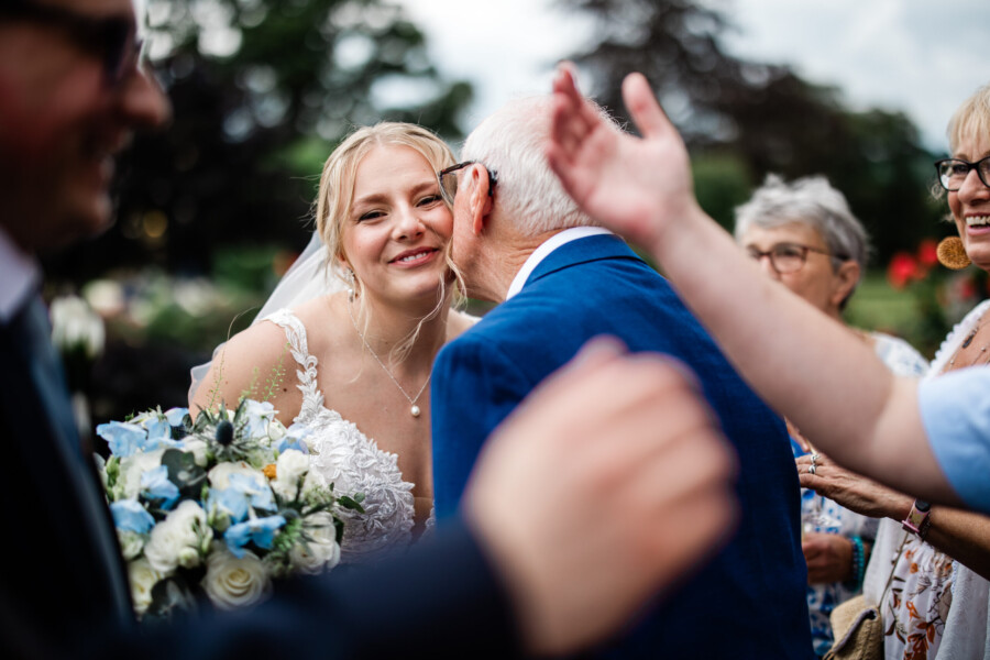 Wedding guests greet each other, during a wedding at Pynes House luxury wedding venue in Devon