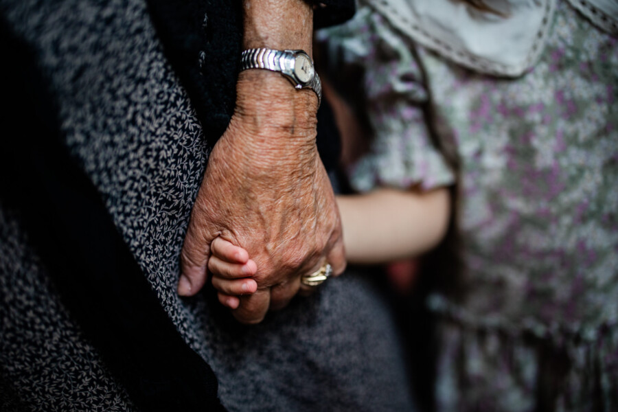 A heartfelt moment as a little girl holds her grandmother's hand