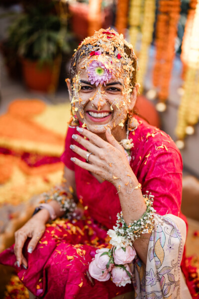 An Indian bride smiles after the haldi ceremony, during destination wedding photography in India