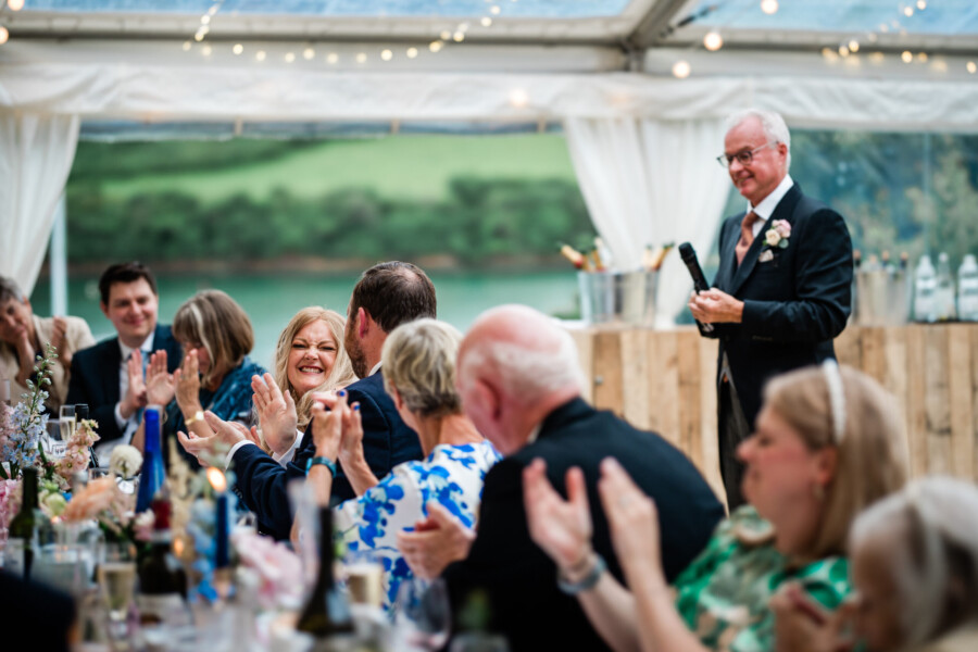 A candid moment during speeches at a marquee wedding in Salcombe, by a wedding photographer UK