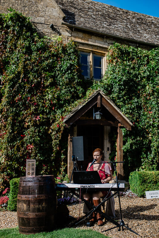 A pianist plays during an outdoor wedding reception in the Cotswolds