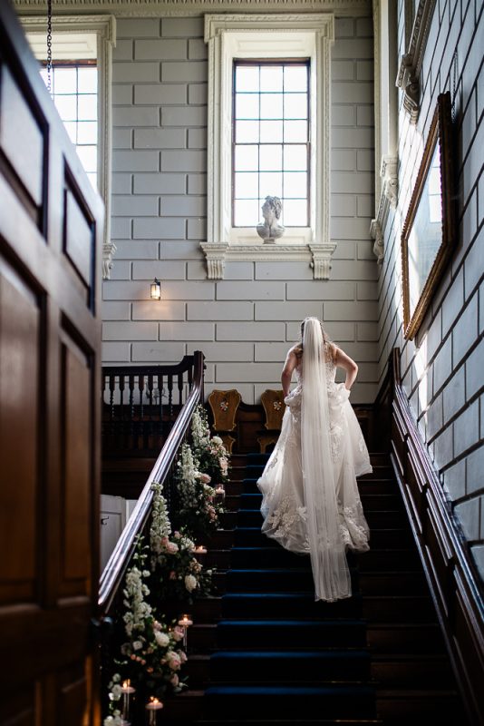 Davenport House wedding photographer capture of a bride running up the stairs, before her wedding ceremony