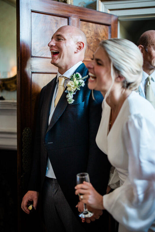 A candid moment between a bride and groom during wedding speeches at an English country house