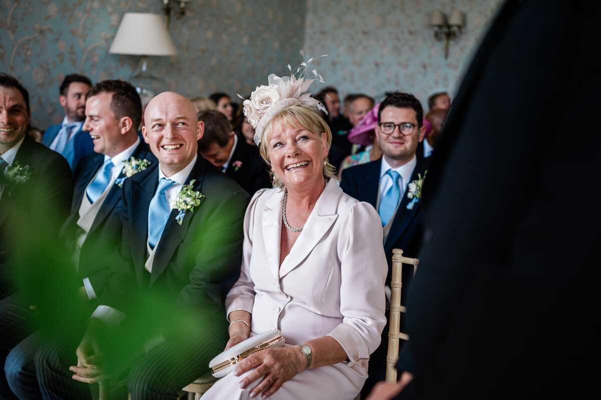 Candid wedding photography of a mother looking up to her son during the wedding ceremony