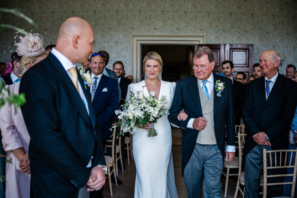 the bride walks down the aisle during a Pynes house wedding